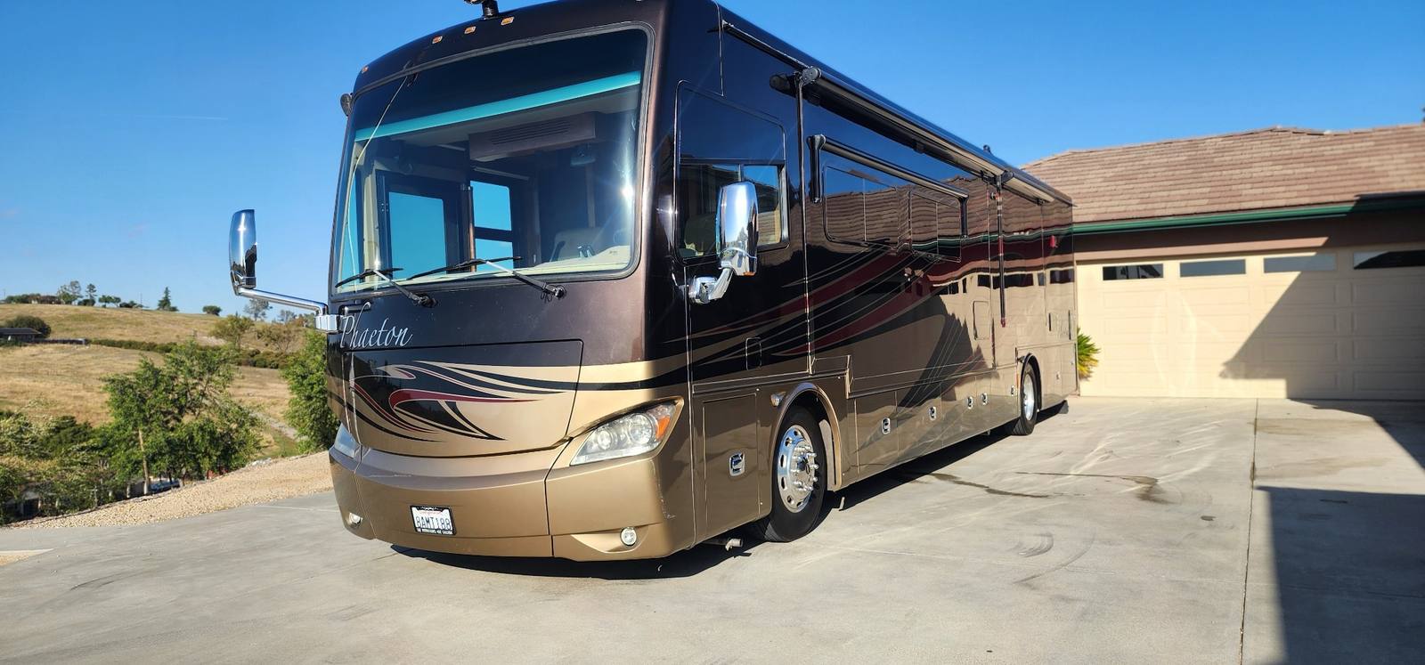 Tiffin Phaeton Class A motorhome with glossy exterior detail on residential driveway